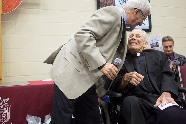 Harvey Barsanti embraces Father Brian Higgins during a ceremony today at St. Mary's College. Kenneth Armstrong/SooToday