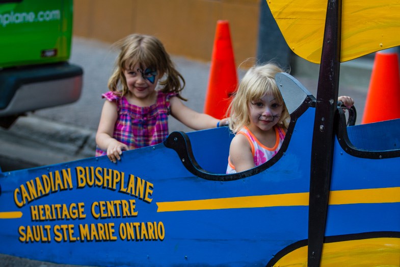 Kids pose for pictures at the Bushplane Museum booth during the Downtown Street Party Thursday, July 17, 2014. Donna Hopper/SooToday.com