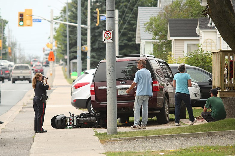 A Sault Ste. Marie Police Service officer takes photos at the scene of an e-bike collision on Wellington Street on August 11, 2014. SooToday.com/Kenneth Armstrong