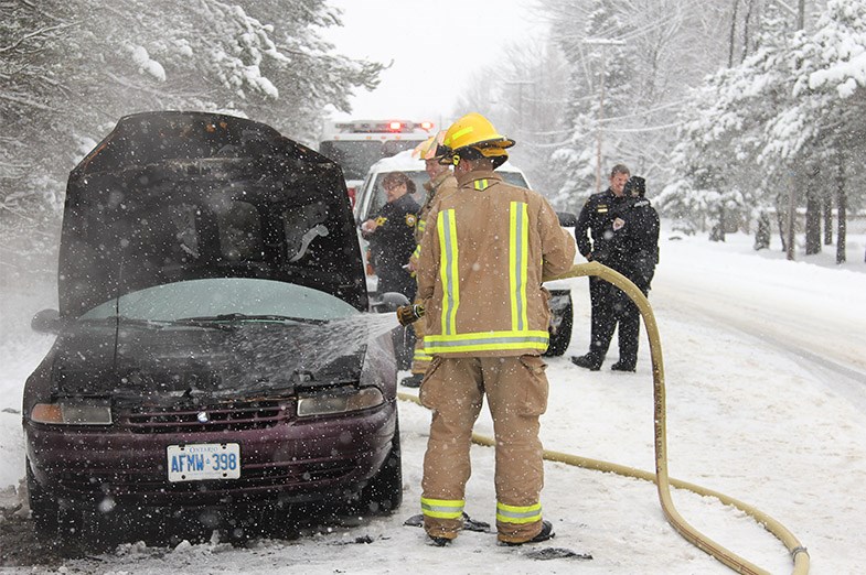 A car fire is extinguished by a Sault Ste. Marie Fire Services firefighter on November 13, 2014 on Frontenac Street. Kenneth Armstrong/SooToday
