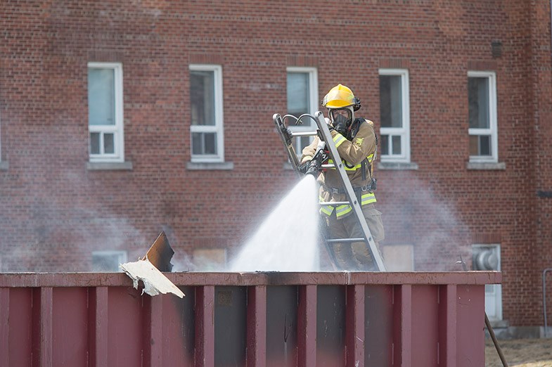 A firefighters with the Sault Ste. Marie Fire Services extinguishes a fire in a waste container at the former Plummer Site on April 29, 2015. Kenneth Armstrong/SooToday