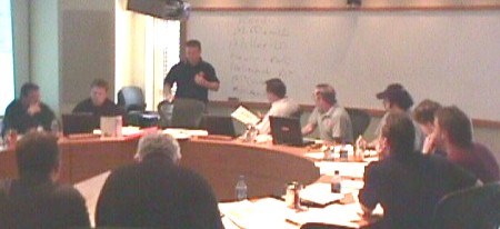 <b>Led by general manager Dave Torrie (standing), the Greyhounds draft table discusses possible third round selections from the team headquarters at the Water Tower Inn.
