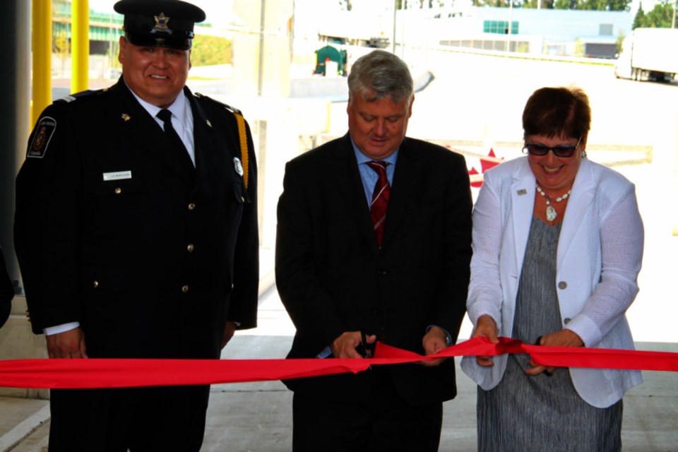 Sault MP Terry Sheehan, flanked by J.D. Marchand, Canada Border Services Agency (CBSA) regional Indigenous Affairs advisor and Micheline Dube, Federal Bridge Corporation Limited (FBCL) president and CEO, cuts the ribbon at the Sault Ste. Marie Port of Entry official opening, Aug. 15, 2018. Darren Taylor/SooToday