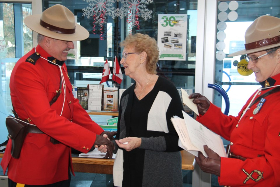 Fulfilling a long-held wish to visit the Canadian Bushplane Heritage Centre, Ann Roger, a Manitoulin Island native now living in southern Ontario, is greeted at the museum by Sault RCMP detachment Constables Earl Dalphy and Dan Chevalier, Dec. 2, 2019. Darren Taylor/SooToday