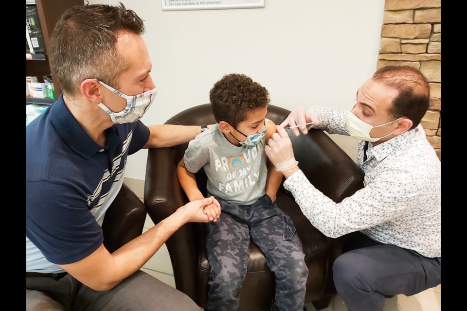 Adel Saleeb, Pharmasave Adel's Pharmacy owner and pharmacist, administers the pediatric Pfizer COVID-19 vaccine to seven-year-old Toby Keuhl while father 
Dr. Jonathan Keuhl lends support, Nov. 30, 2021. Darren Taylor/SooToday