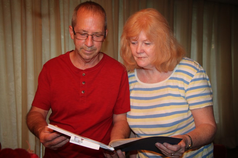 Dan Giddens and Kathy Millette of Sault Ste. Marie browse through a book of wartime memoirs written by their father Ron Giddens, August 16, 2016. Darren Taylor/SooToday  