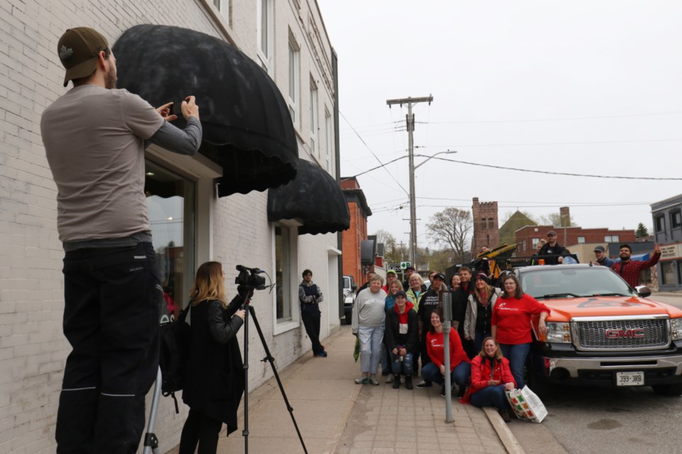 Downtown Association General Manager Josh Ingram, left, uses a step ladder to snap a photo of the group assembled for the association's first annual downtown spring cleanup Saturday morning. James Hopkin/SooToday