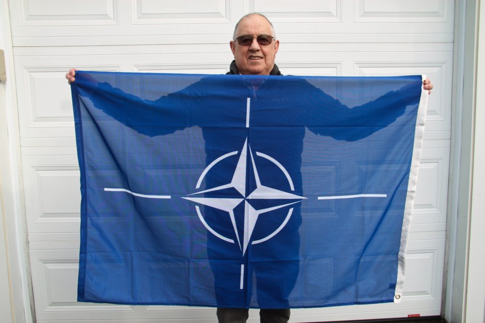 Peter Pozzo with a NATO flag gifted to him by neighbour Stephen Givens, March 12, 2024.