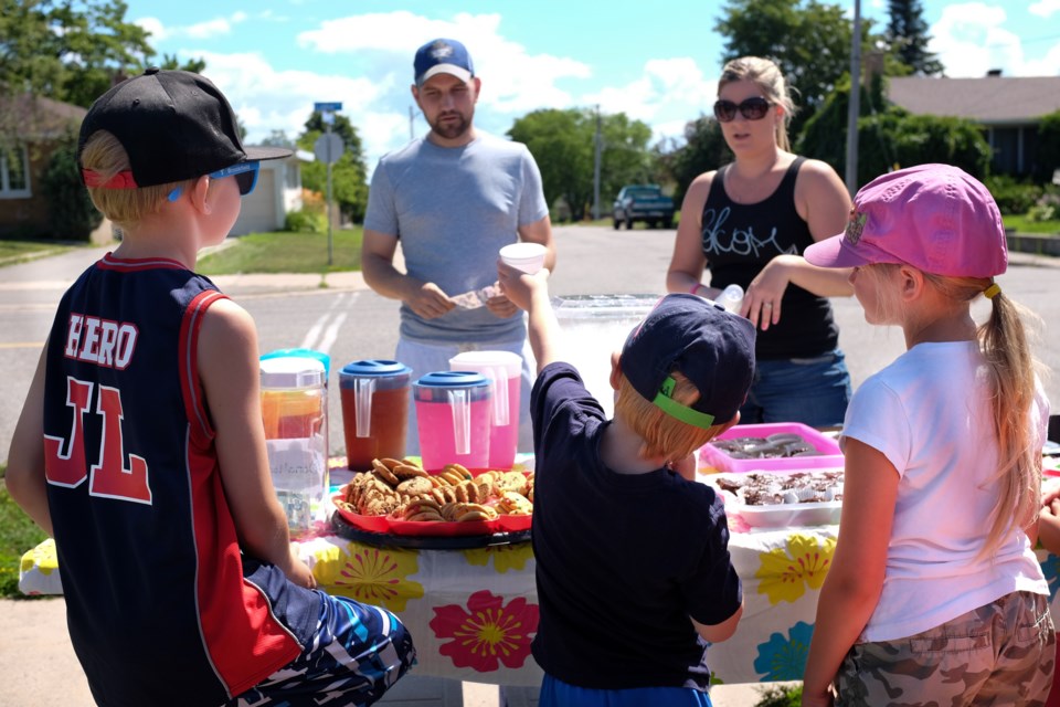 The Haynes family set up a Lemonade stand on Lake Street on Saturday, raising $310.50 for local charities. The parents said they were doing it to teach their kids about 'karma'. Photo by Jeff Klassen for Sootoday