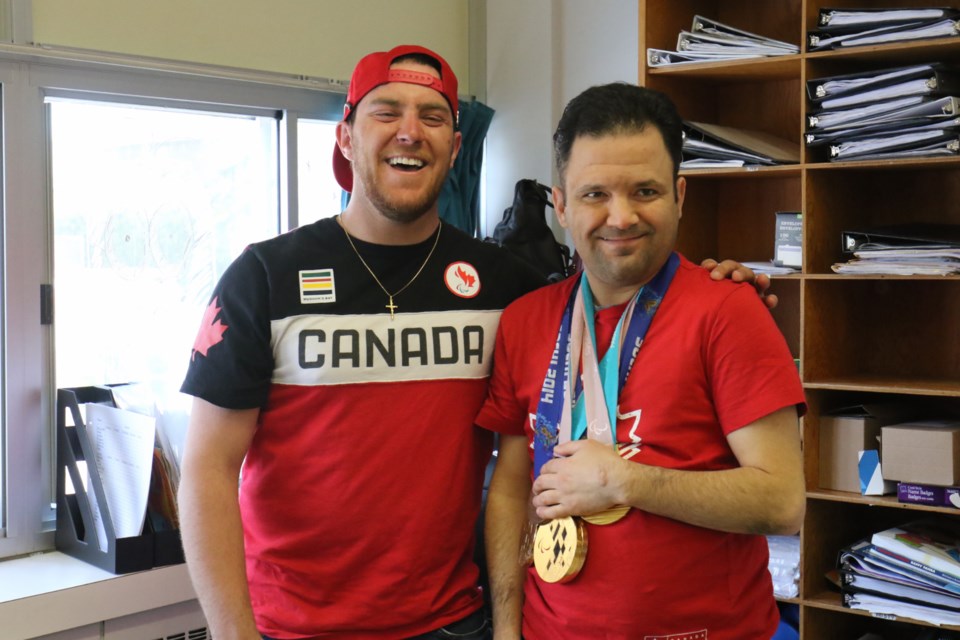 Local paralympic skier Mac Marcoux, left, gets his picture taken with Jon Caputo, a participant in Breaking Away, a local program for adults with developmental disabilities. James Hopkin/SooToday