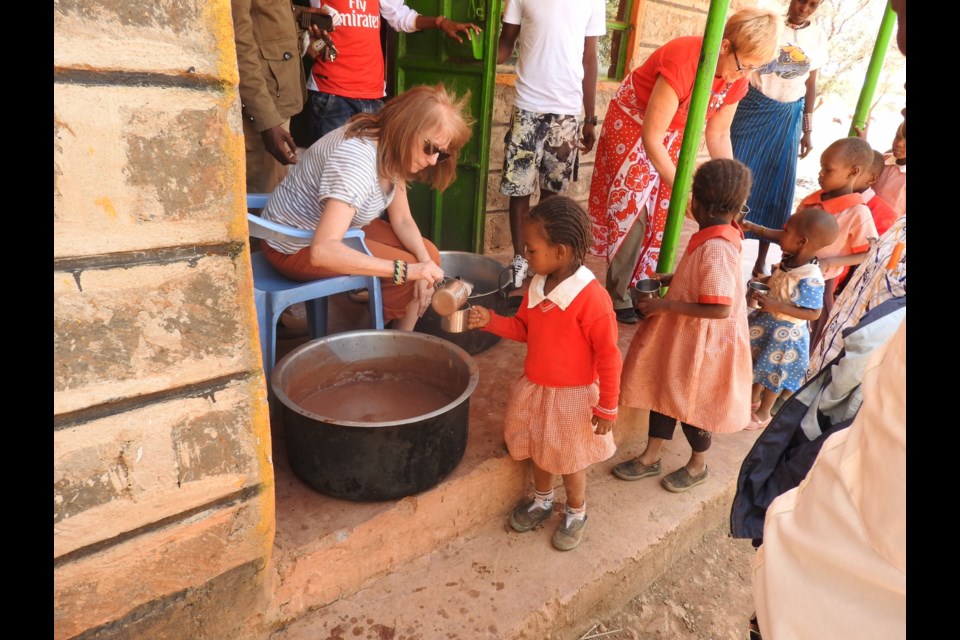 Sylvie Mackey, left, and Sheree Wilson, right, serve uji - a Kenyan porridge - in Namuncha, Kenya. Photo supplied by Holly Wickett       