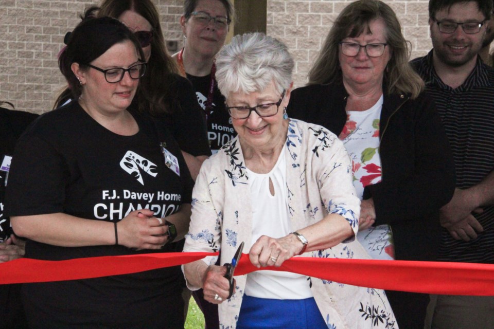 Fran Burns, widow of past FJ Davey Home resident Bob Burns, cuts the ribbon on a new gazebo dedicated to her husband’s memory on Thursday. 