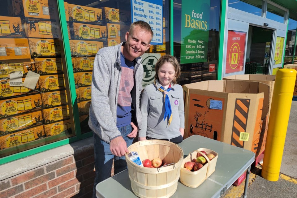 Kallen Bruwer with father Pieter Bruwer at Apple Day outside Food Basics on Pine Street on Oct. 14, 2023.