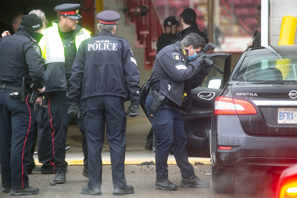 A forensics officer with the Sault Ste. Marie Police Service photographs the scene of a collision at GFL Memorial Gardens on March 17.