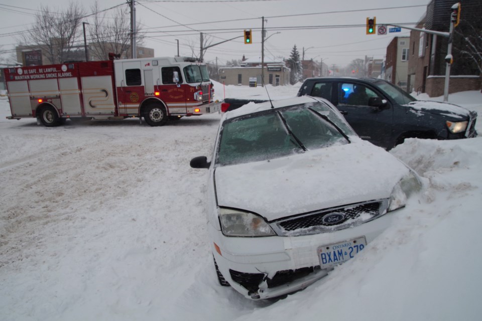 A white car is lodged in a snowbank following a collision at Spring and Bay this morning. Michael Purvis/SooToday