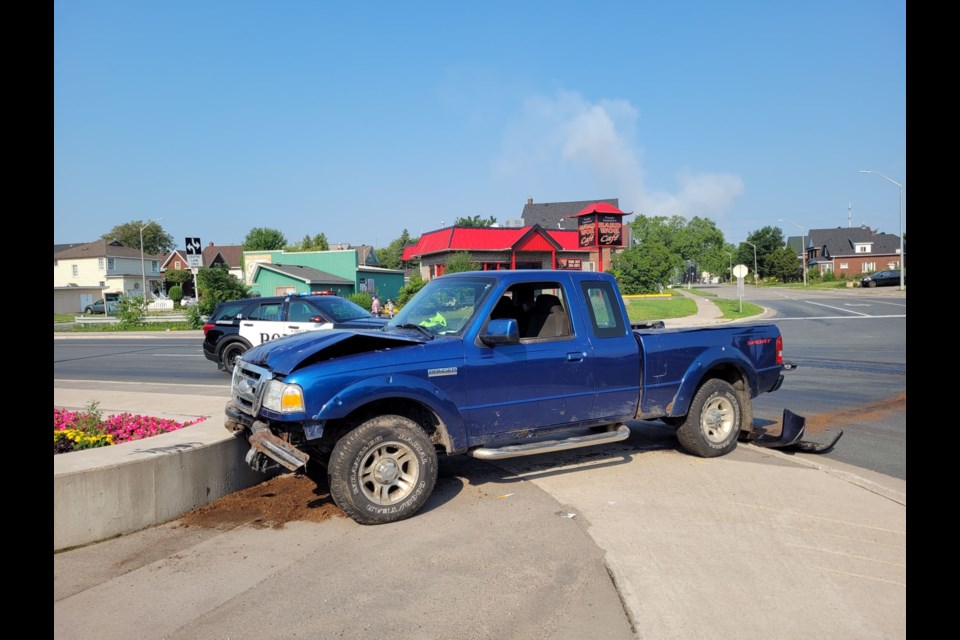 A blue pickup truck came to rest on the concrete bench installed on the city's circle garden on the corner of Cathcart and Huron Streets on Monday morning. 