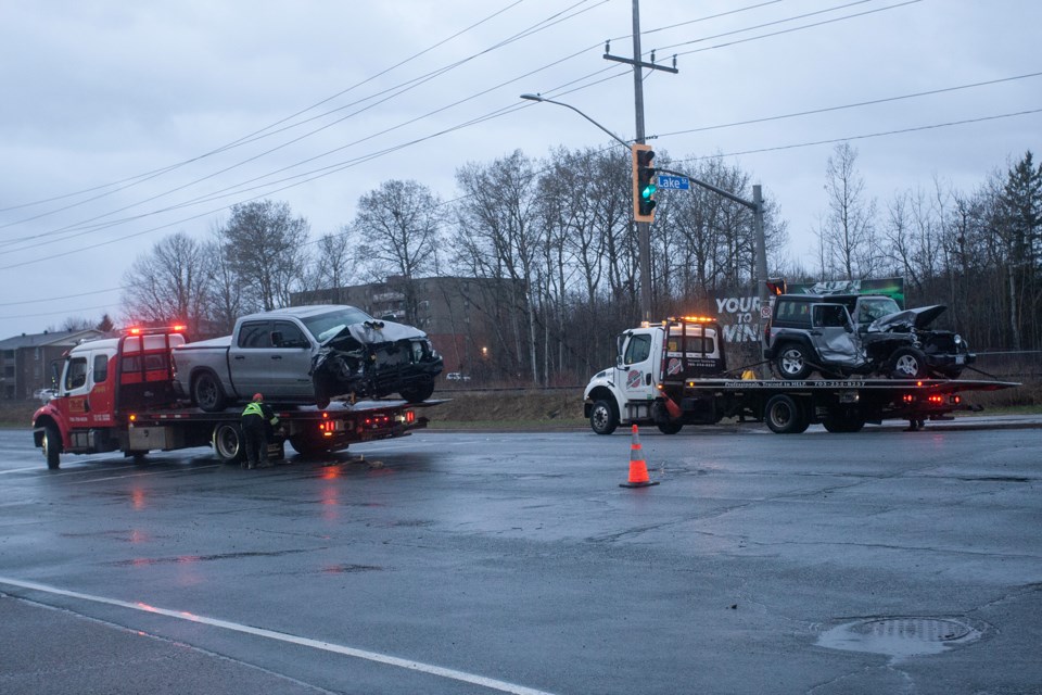 Two vehicles, each with front-end damage, are removed from the scene of an early-morning collision at the intersection of Trunk Road and Lake Street on April 12, 2024.