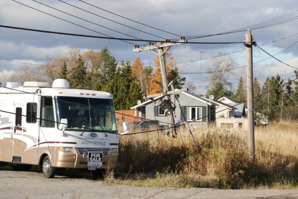 A truck hauling construction equipment snagged and pulled down a live power line on Black Road Sunday. Jeff Klassen/SooToday