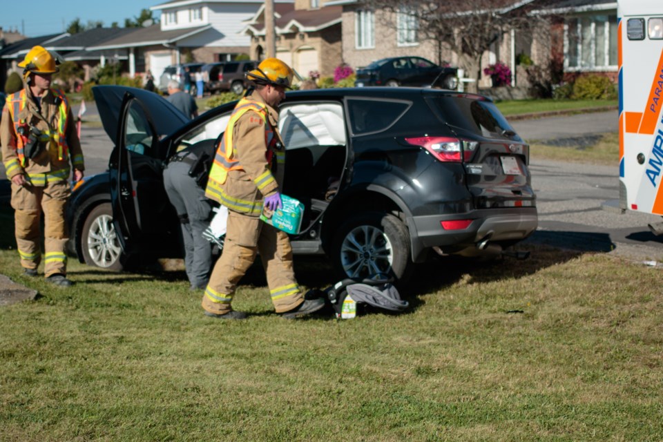A firefighter carries diapers and a bag to an ambulance. An 11-month-old baby and and adult were taken to the hospital after a collision at Strand Avenue and Wilson Street today said Captain Steve Quesnelle with Sault Ste. Marie Fire Services. Jeff Klassen/SooToday