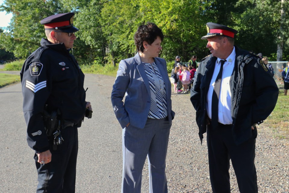 Sgt. Ray Magnan, left, and city police chief Hugh Stevenson speak with Huron-Superior Catholic District School Board Director of Education Rose Burton Spohn on the first day of school. James Hopkin/SooToday 