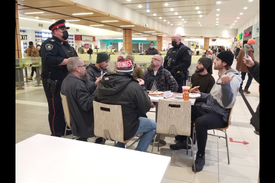 Members of Sault Ste. Marie Police Service speak to a group of people seated at the Station Mall food court Friday. 
