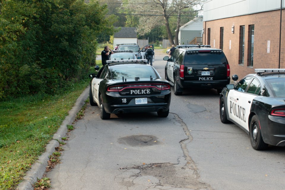 Police officers investigated the bushes around the Second Line West and Goulais Avenue Northern Credit Union and nearby apartment building Friday morning as part of an investigation after a home invasion that had taken place just a couple hours earlier on Third Avenue. Jeff Klassen/SooToday