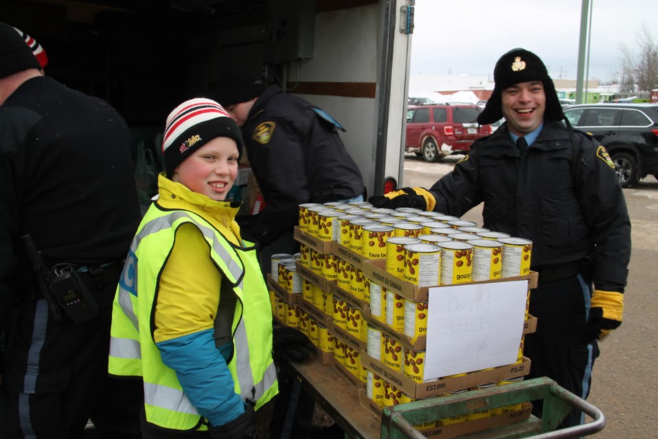 Carter McClelland and Sault OPP auxiliary unit officer Dustin Mann at the 15th annual OPP Stuff a Cruiser to help families in need outside Rome’s Your Independent Grocer, all donations of food and monetary donations going to the Sault Ste. Marie Soup Kitchen Community Centre, Dec. 8, 2018. Darren Taylor/SooToday