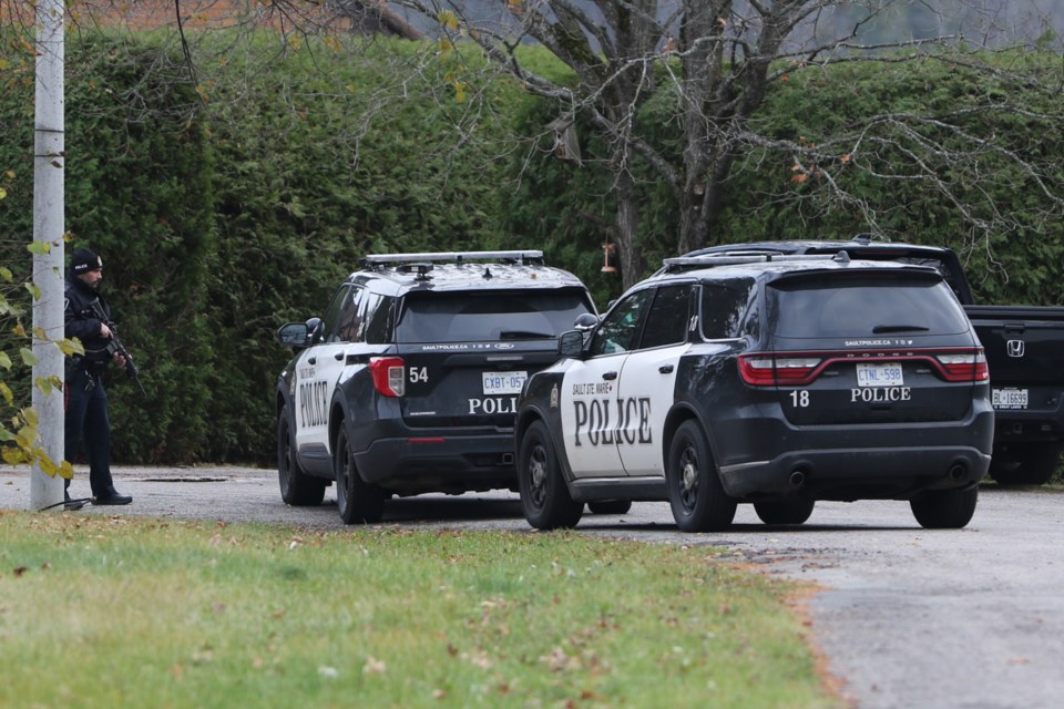 A lone armed officer with Sault Ste. Marie Police Service stands outside of a home on Barber Blvd. Friday afternoon