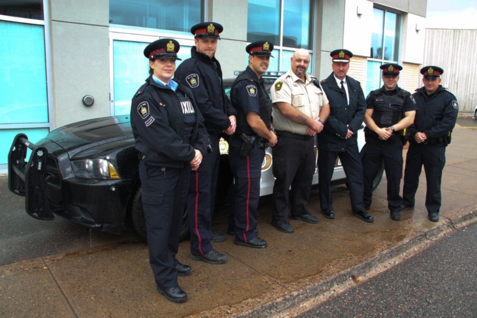 Dalaina Orr, Sault Police Auxiliary Unit, Sault Police Constable Trevor Pluss, Constable Sonny Spina, Phil Bumbaco, Station Mall security supervisor, Sault Police Chief Hugh Stevenson, Constable Ryan Lillington and Sergeant Darin Rossetto with a police cruiser outside the Sault Police satellite station located at Station Mall, Oct. 12, 2018. Darren Taylor/SooToday    