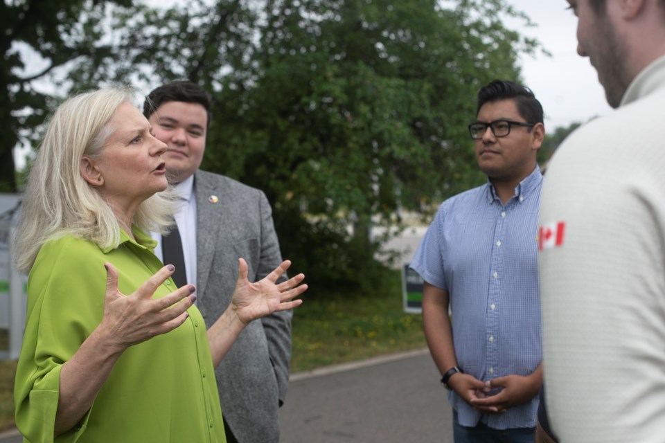 Mayoral candiate Donna Hilsinger speaks while ward candidates Marek McLeod and Luis Moreno listen in the background during a campaign launch Wednesday outside the Canadian Bushplane Heritage Centre.