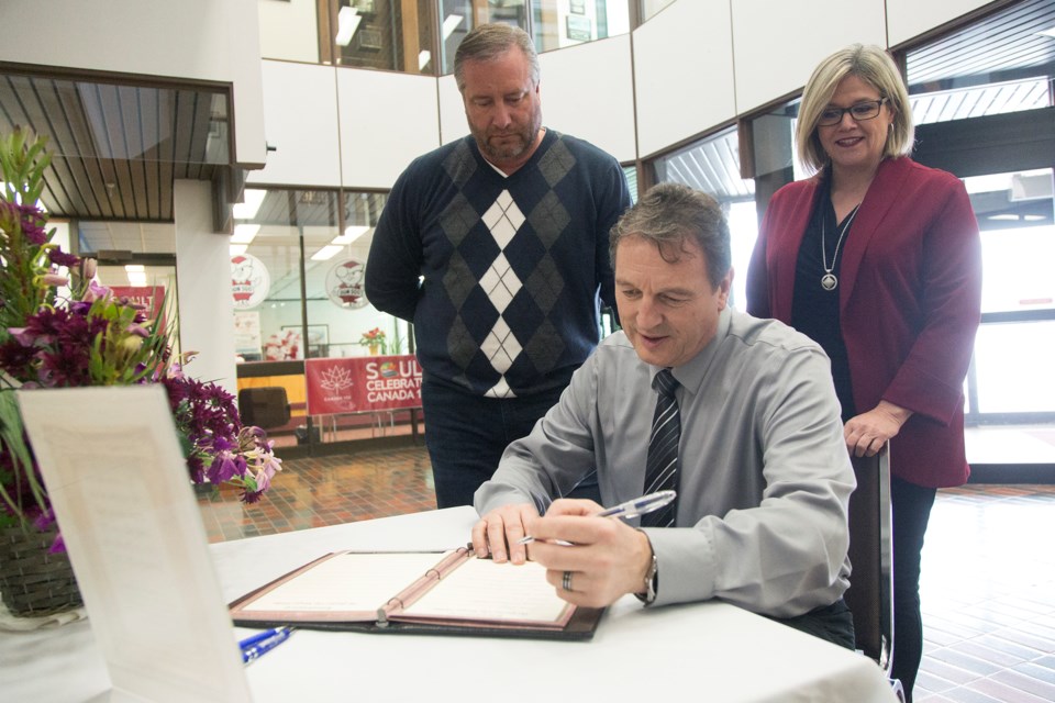 Joe Krmpotich signs a book of condolences as MPP Mike Mantha and NDP leader Andrea Horwath look on this morning for the victims of the attack on a Quebec City mosque, which occurred late last month. Kenneth Armstrong/SooToday
