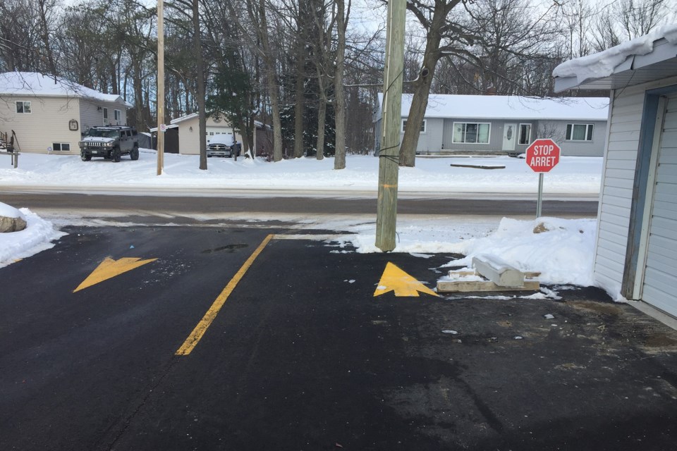 Original photo taken last month of an arrow in the parking lot exit pointing to the utility pole.