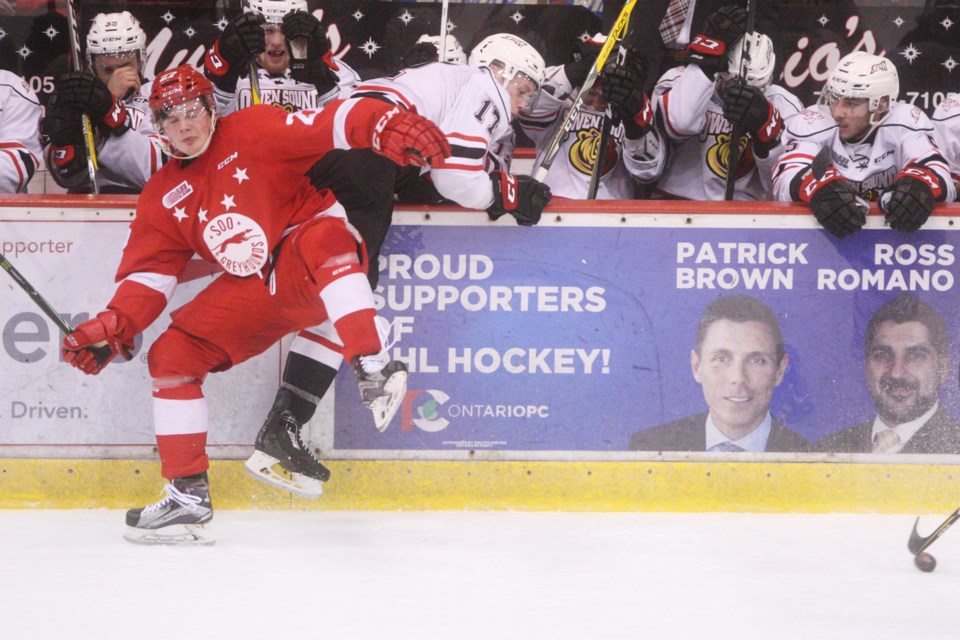 Soo Greyhounds' Barrett Hayton collides with Trenton Bourque in front of the Owen Sound Attack bench during Game 5 of their playoff series played Apr. 14, 2017 at the Essar Centre in Sault Ste. Marie. Kenneth Armstrong/SooToday 