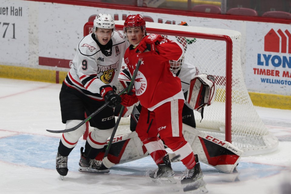 Soo Greyhounds forward Justin Cloutier battles Owen Sound Attack defenceman Sam Sedley at the GFL Memorial Gardens on Jan. 15, 2022.