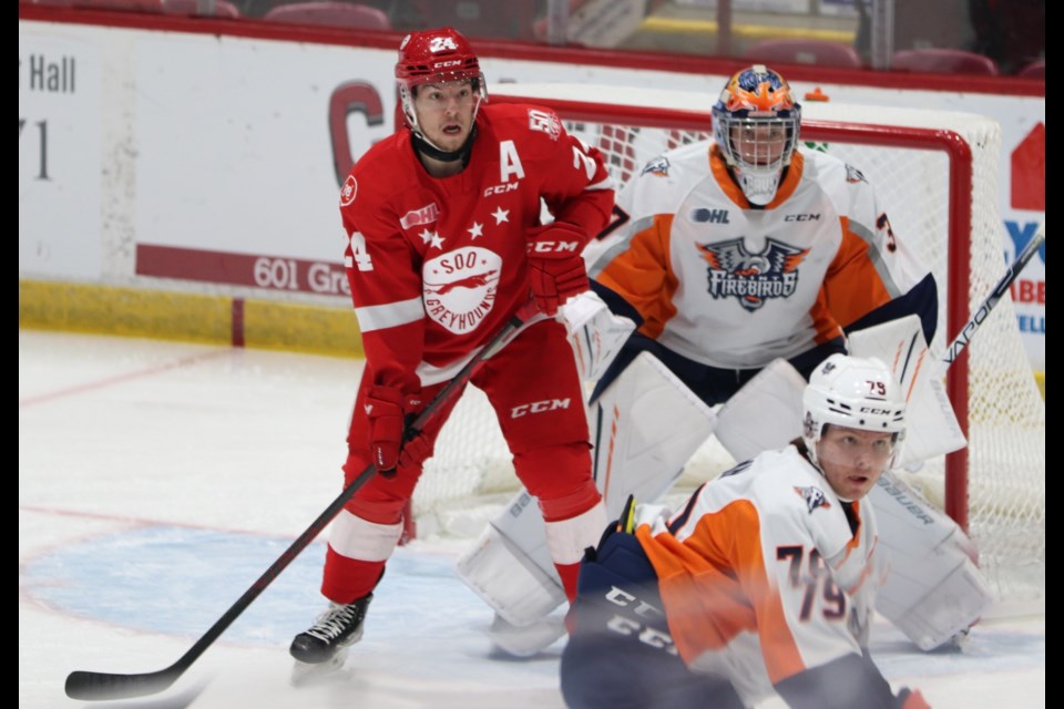 Soo Greyhounds forward Cole MacKay waits for the puck in front of Flint Firebirds goalteder Luke Cavallin during a game at the GFL Memorial Gardens on Jan. 28, 2022.