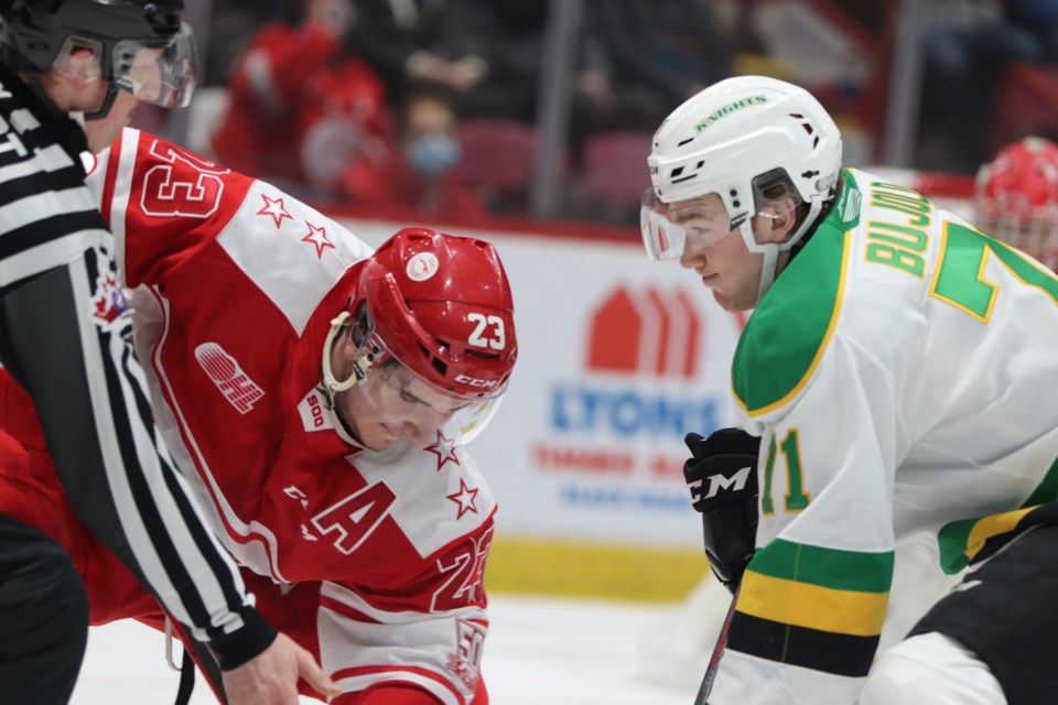 Soo Greyhounds forward Rory Kerins takes a faceoff against London Knights forward Ben Bujold in a game at the GFL Memorial Gardens on Feb. 25, 2022.