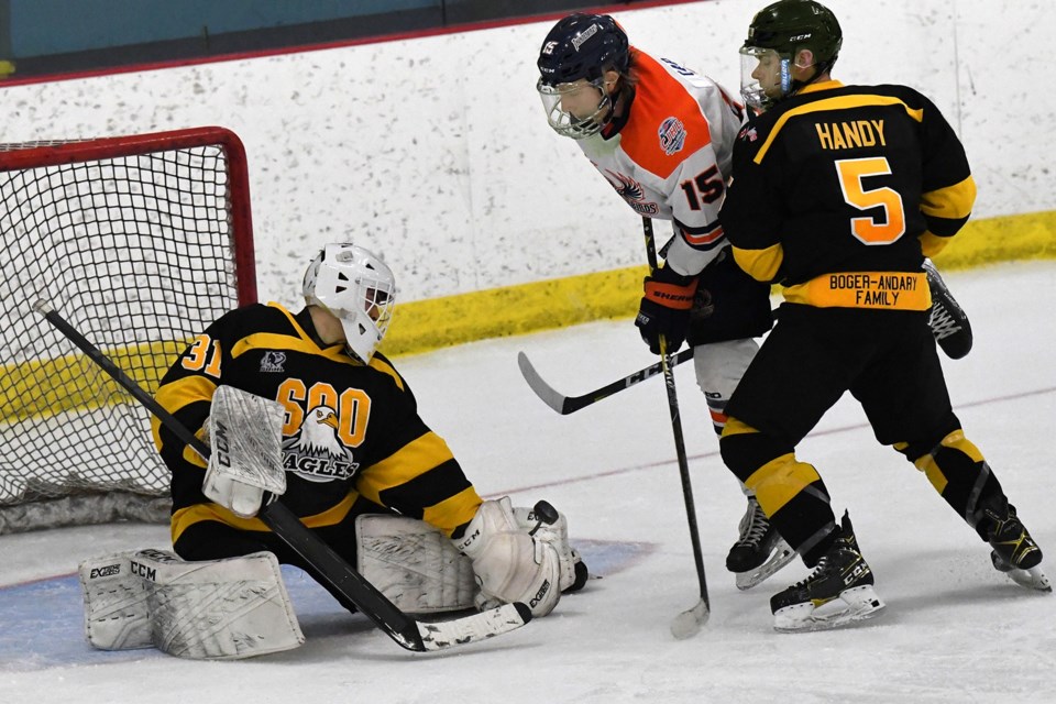 Soo Eagles goaltender Ryan GIlmore makes a save as Soo Thunderbirds forward Dharan Cap and Eagles defenceman Colin Handy battle at the edge of the crease in a Northern Ontario Junior Hockey League game at Pullar Stadium on April 22, 2022.