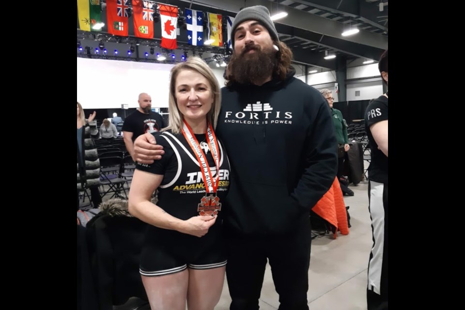 Powerlifter Holly Lasante, left, poses with trainer Austyn Ryan - and her silver medal - during the Canadian Powerlifting Union Nationals in Ottawa. Photo supplied