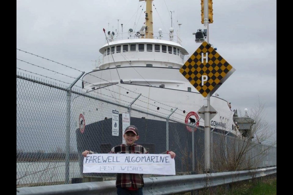 Cameron Shabley, 10, holds up a banner as the Algomarine passes through the Welland Canal on its final journey. Photo courtesy Darryn Shabley