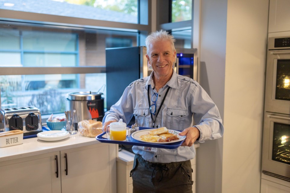 volunteer-greg-bringing-food-to-a-resident-in-their-room