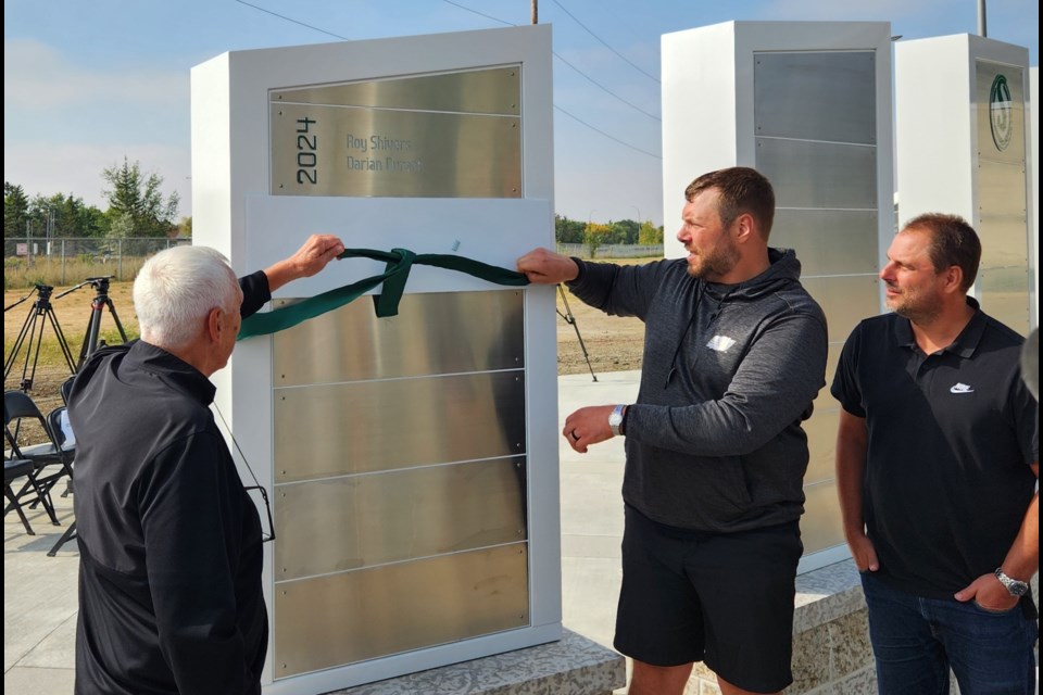 Plaza of Honour 2025 inductees Alex Smith Sr. and Chris best are joined by Jeremy Molnar, son ot Steve Molnar, in revealing the newest plaque.
