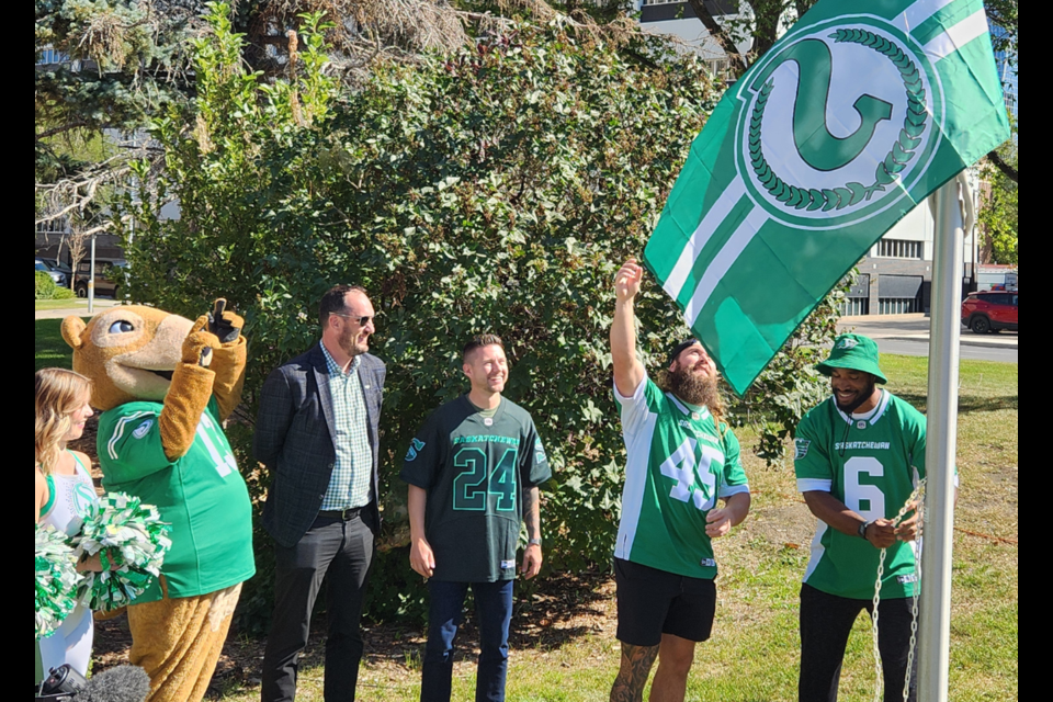 Saskatchewan Roughriders CEO Craig Reynolds, Mayor Chad Bachinsky, running back A.J. Ouellette, and linebacker Jameer Thurman raise the Riders' retro flag at City Hall