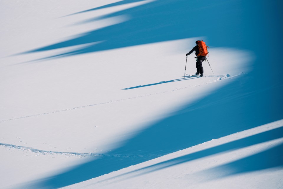 A mountain climber skis up a snow-covered glacier on the Tantalus Range. 