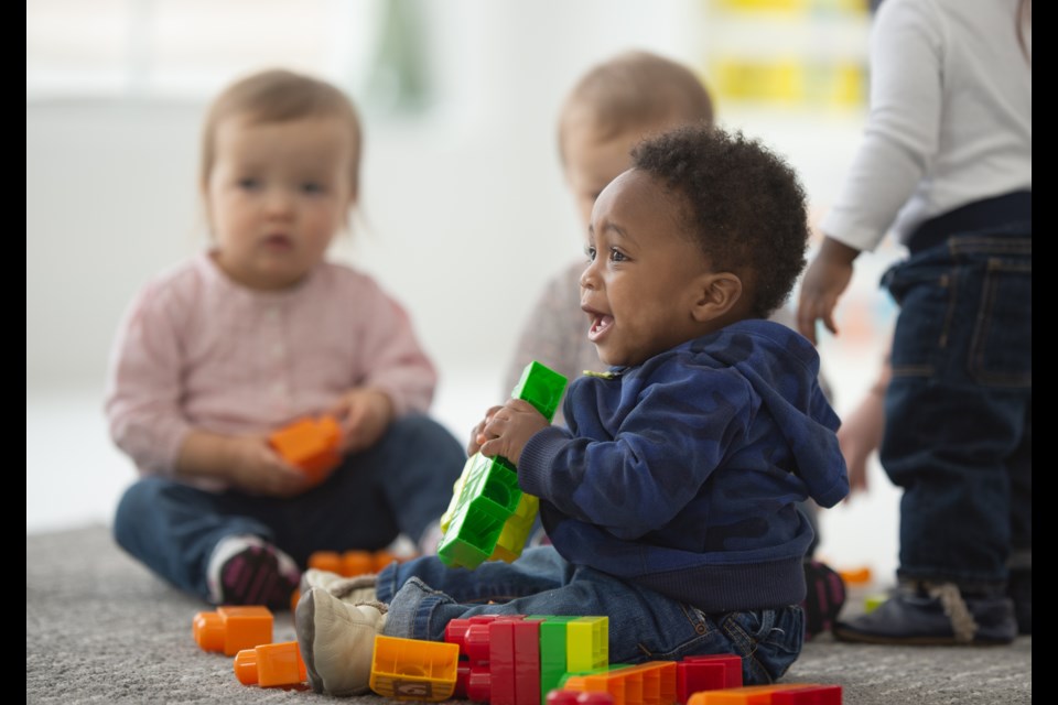 A group of toddlers sit and play with blocks. This age group is the hardest to find day care spots for, locals say.