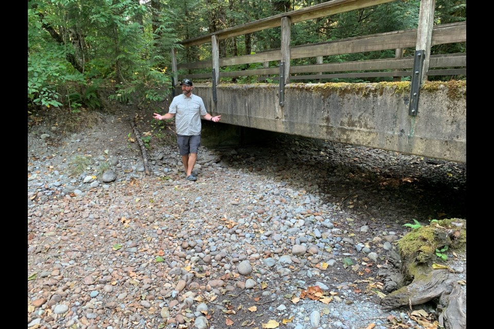 Clint Goyette stands on the bone-dry gravel of the creek bed. 