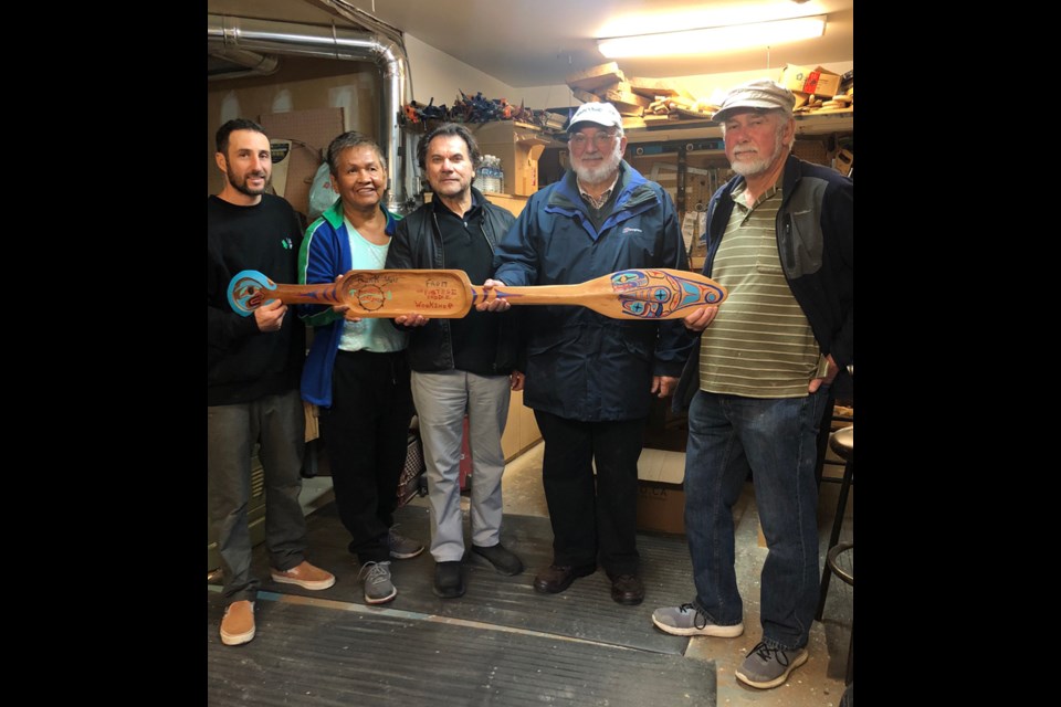 Portage crew Lenny Rubenovitch and Art Harry presenting the Men's shed members with a paddle for their support.