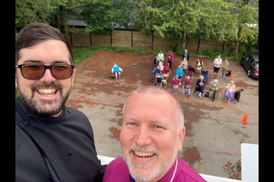 Rev Cameron Gutjahr (here with Bishop John Stephens) spent the night on his church's roof to raise funds for its repair. 