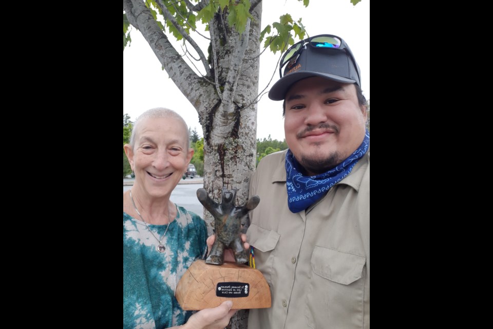 Sherri Green and artist Andre Francois with the carving.