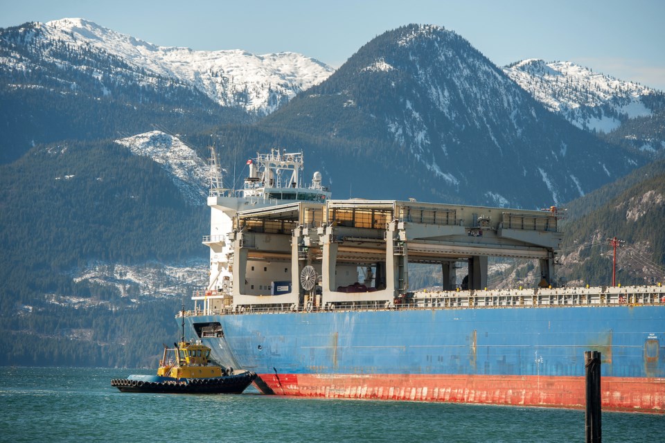 A tugboat helps a freighter cast off at the Squamish Terminals port.  Sunday, March 3rd, 2019.  