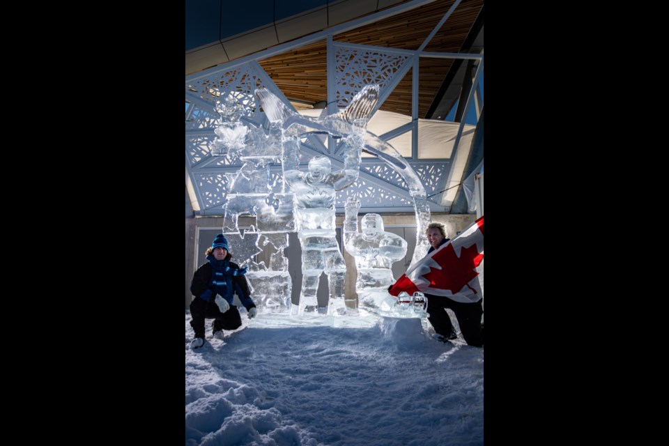 Kevin Lewis (L) and Ryan Cook with a Canadian flag (R) beside their ice sculpture. 